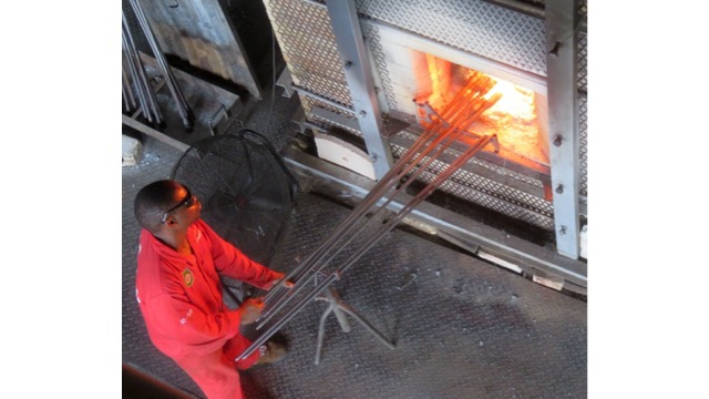 A worker prepares glass to be blown